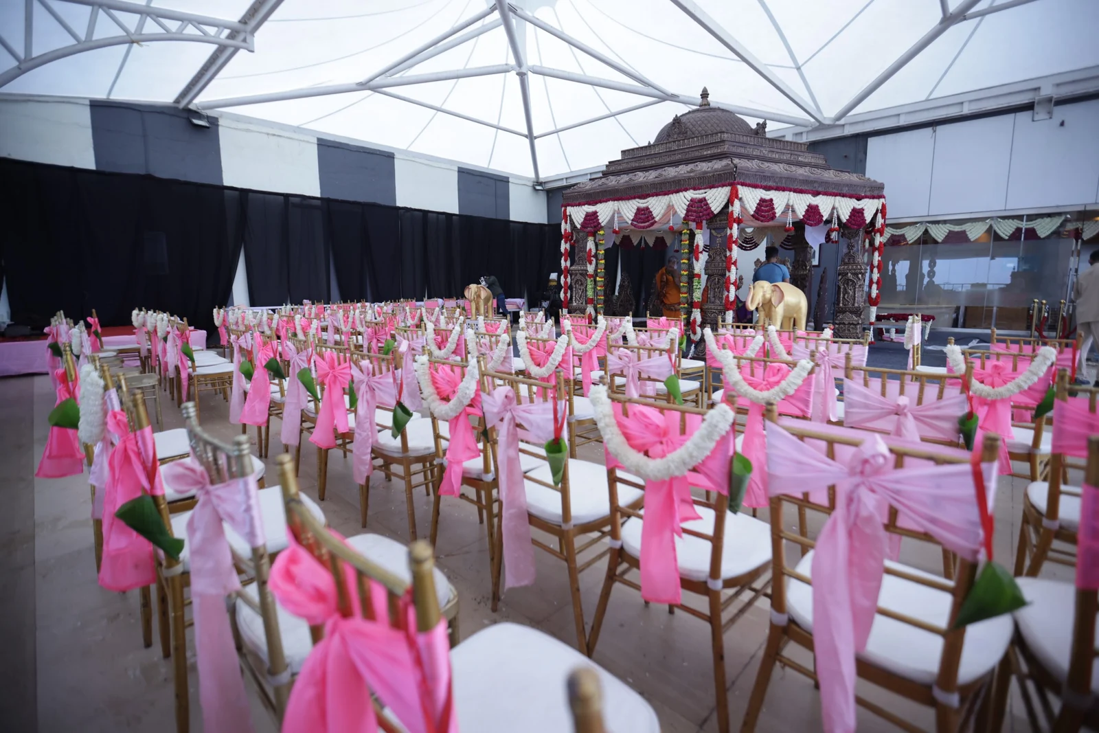 A flower-decorated wedding mandap with a traditional ceremony setting