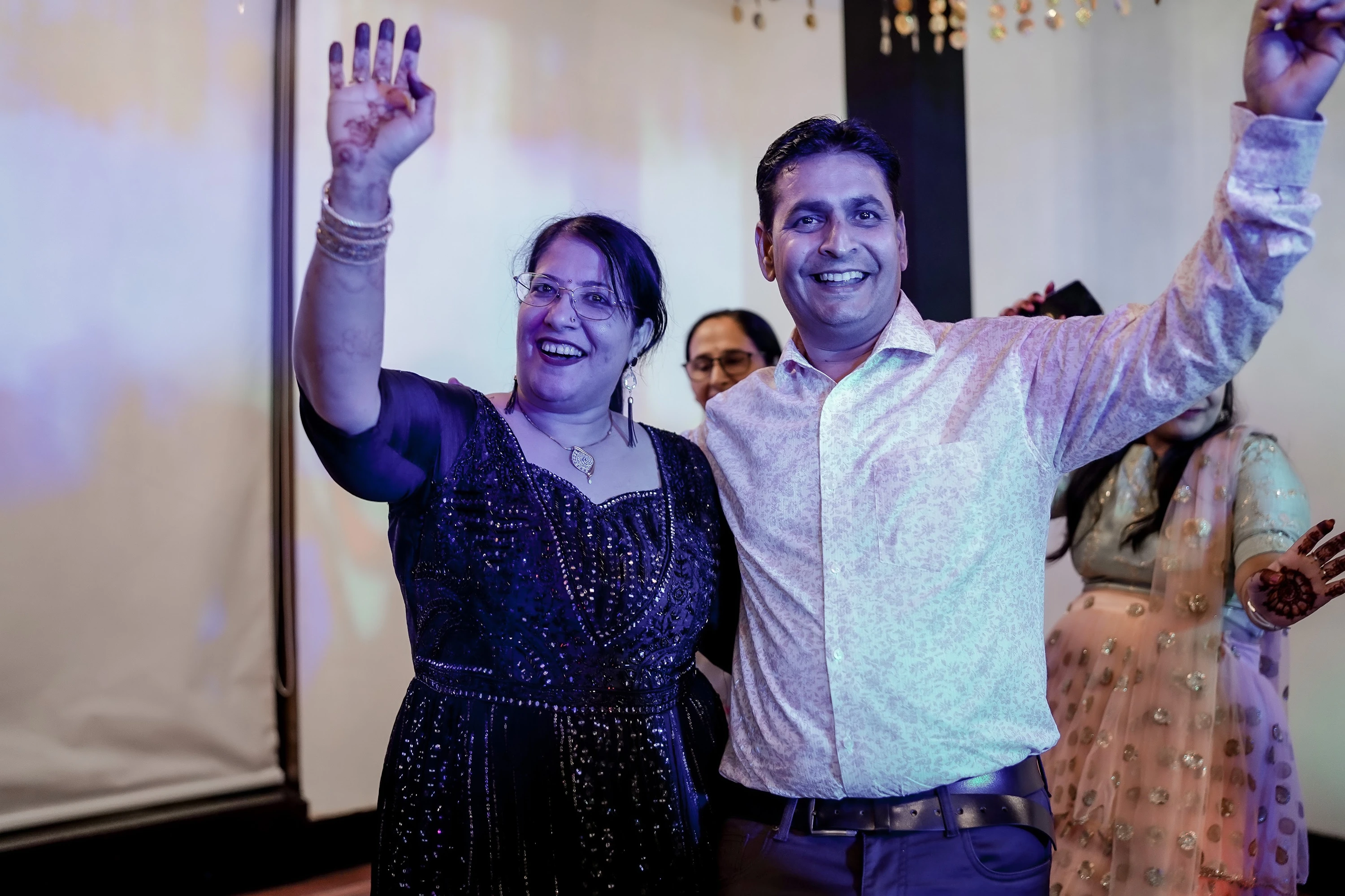 Wedding guests joining the celebration on a warmly lit dance floor.