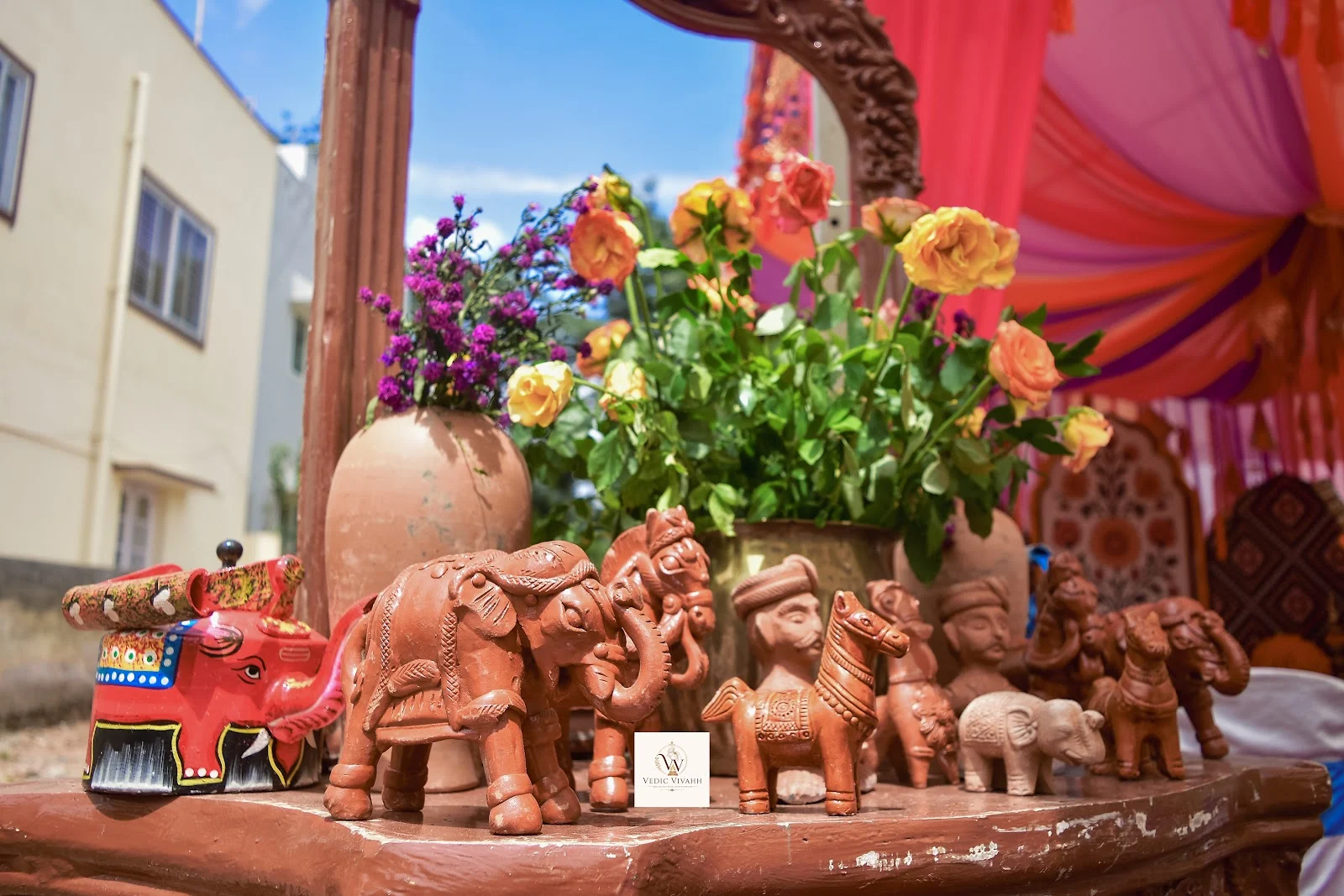 Carved elephant figurines and bright flowers on a traditional display