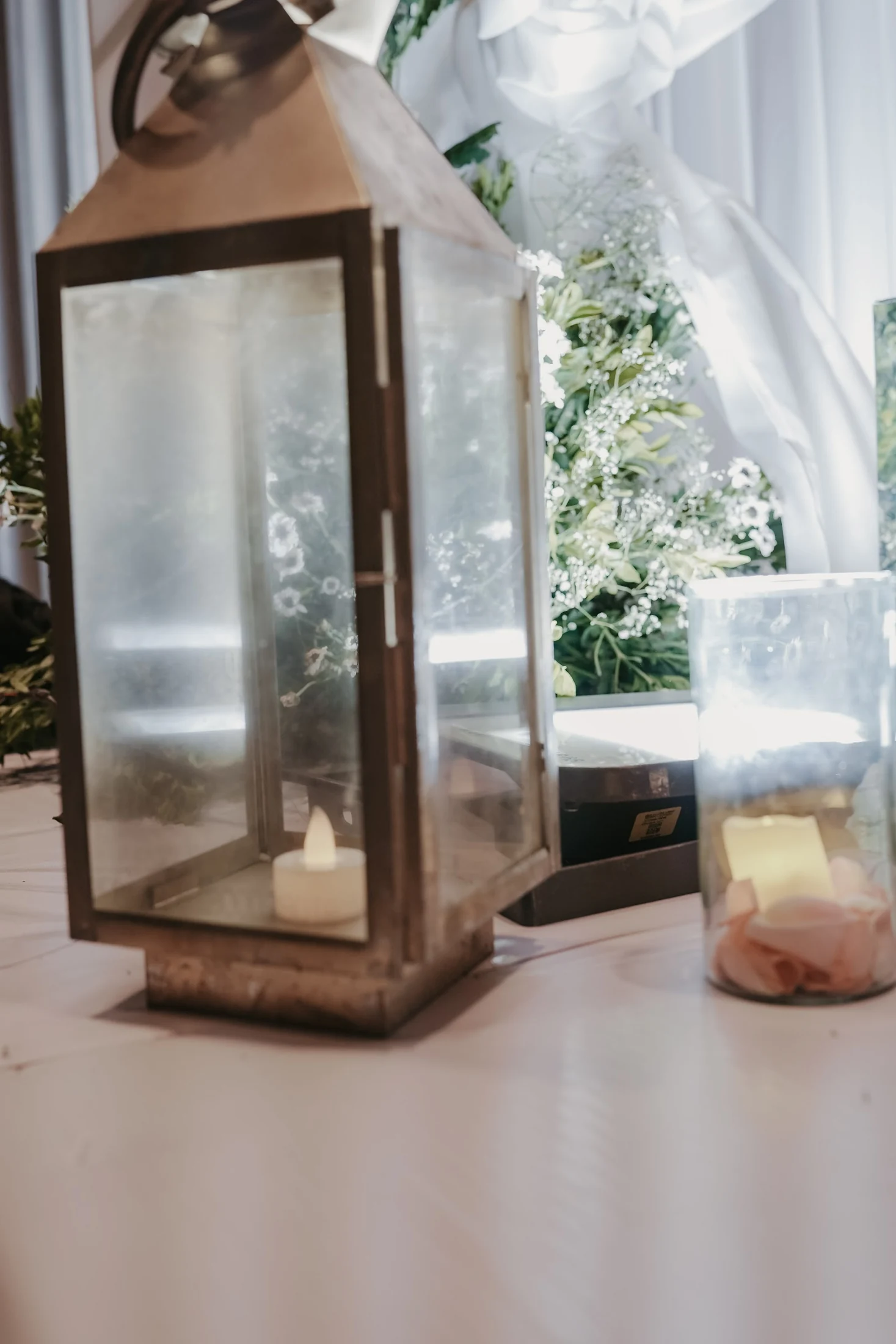 A lantern and candles styled with white flowers