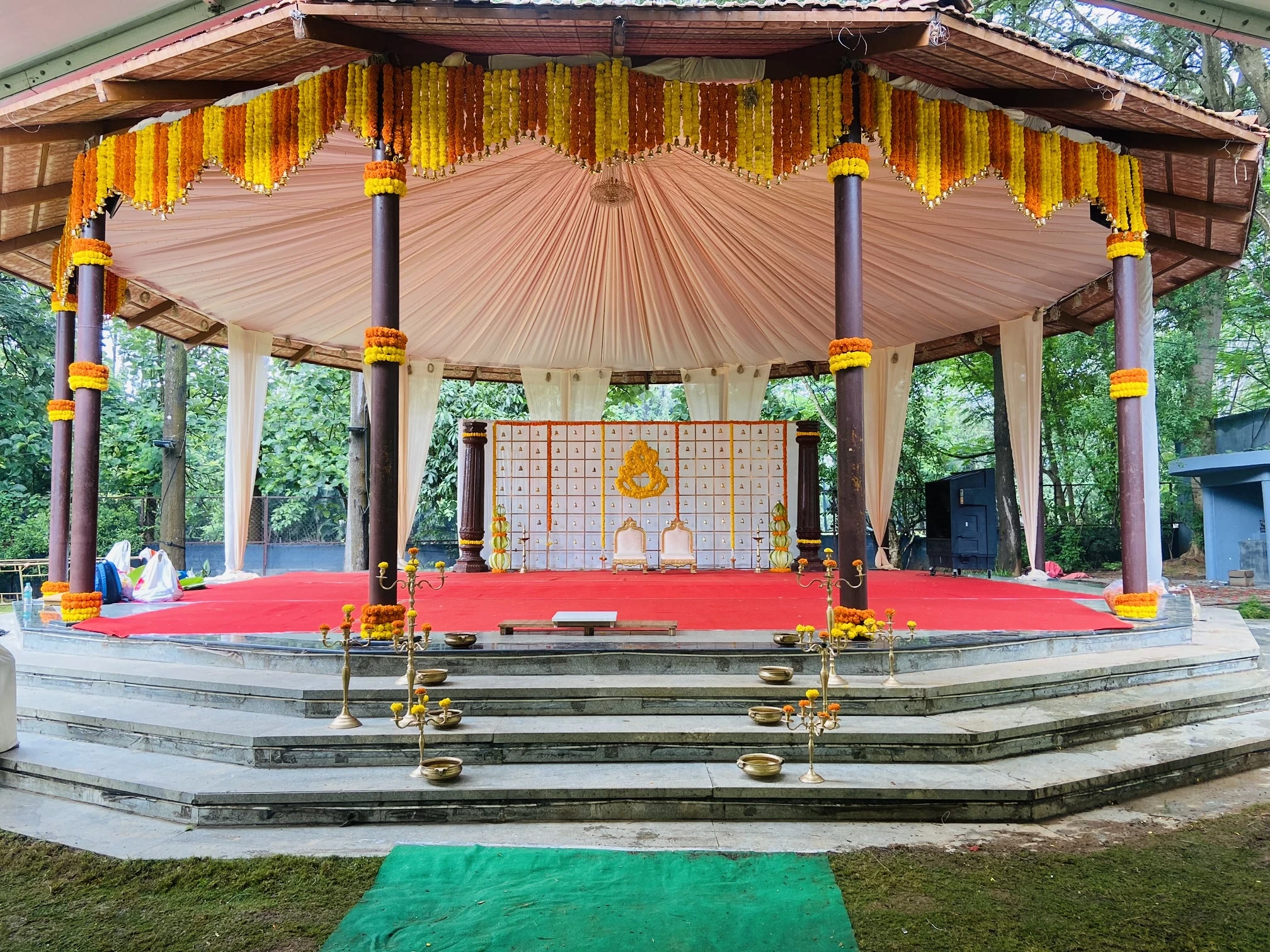 A covered wedding pavilion decorated with orange and yellow marigolds
