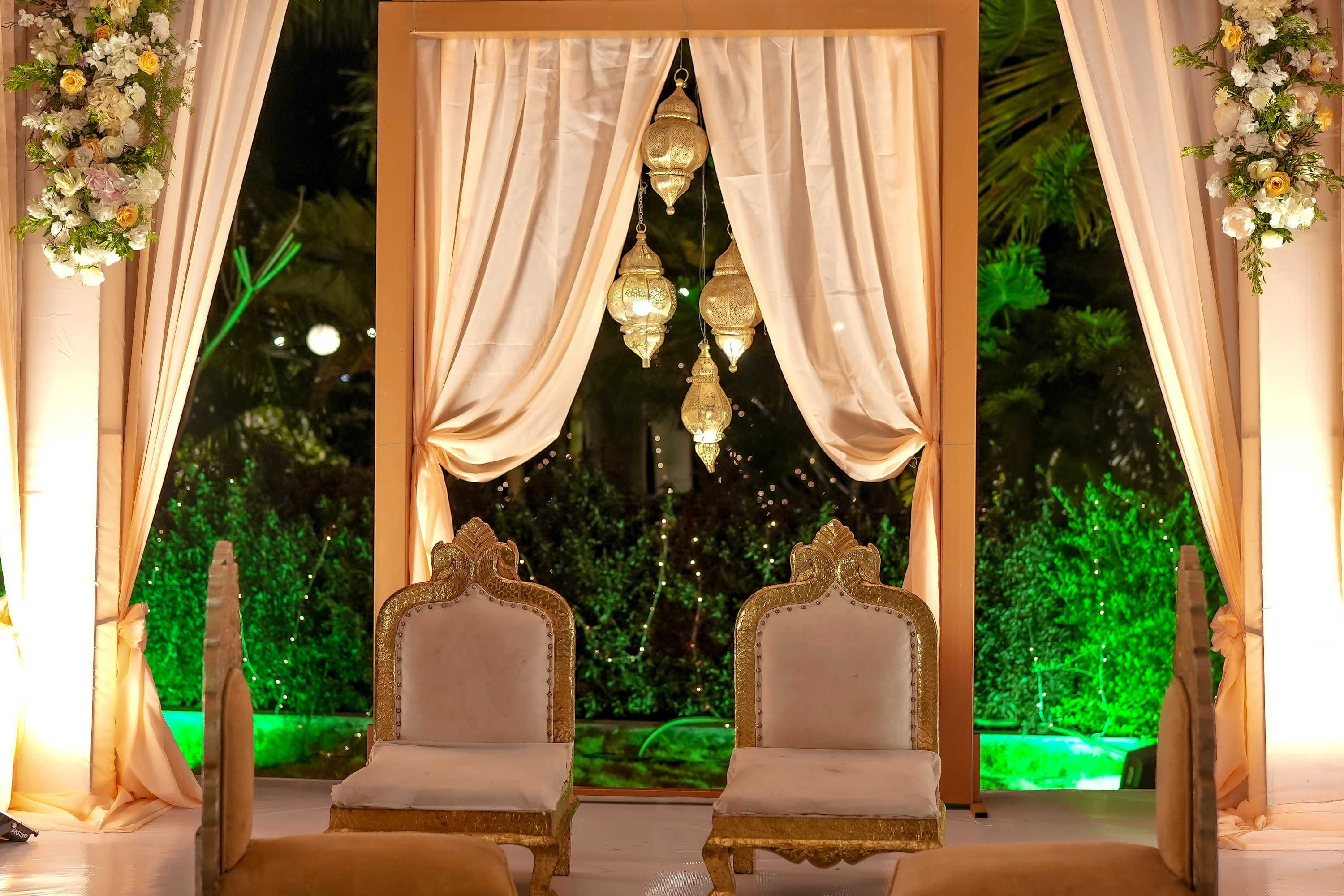 Ceremony chairs arranged beneath warm drapes and hanging lights