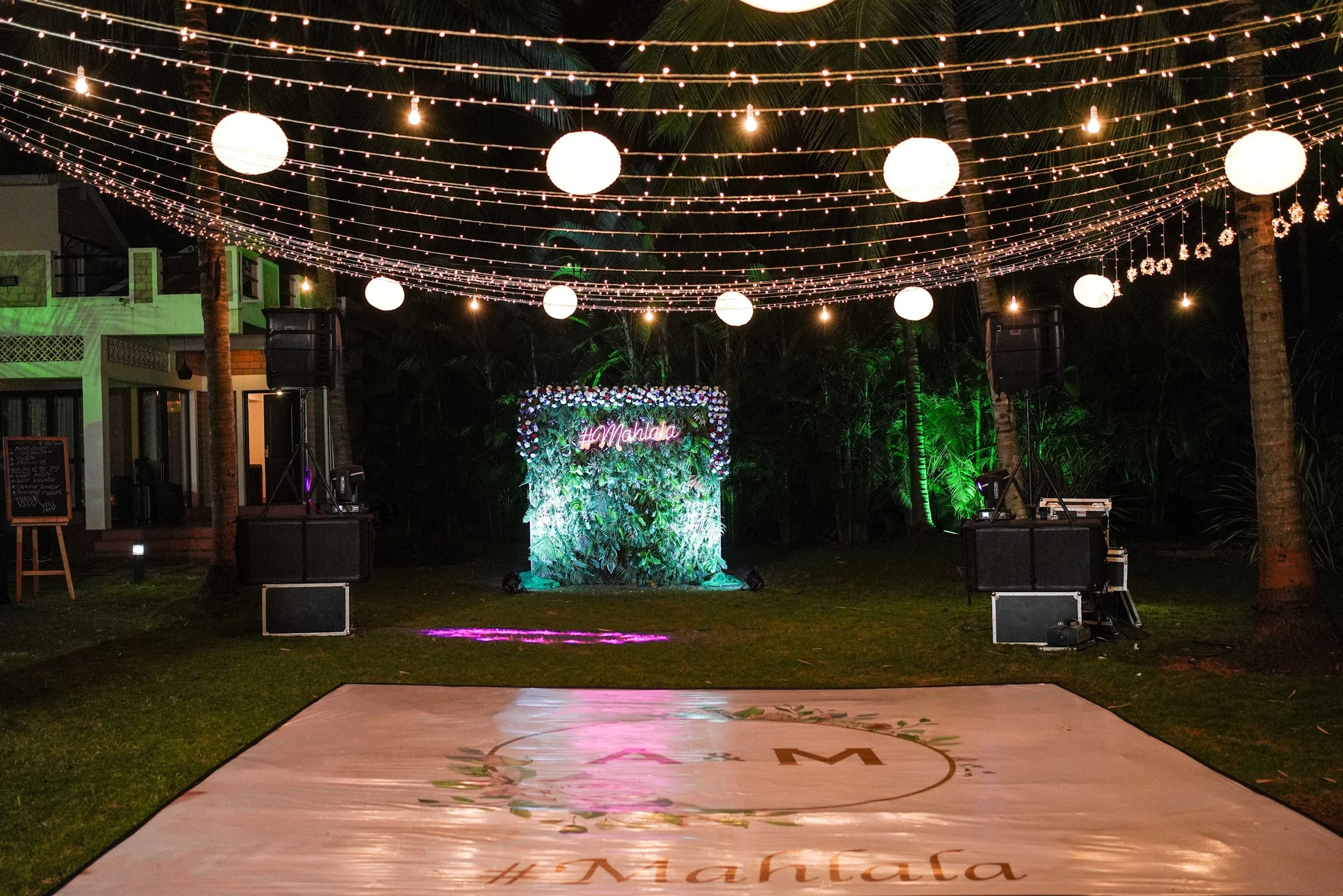 An outdoor dance floor beneath strings of globe lights