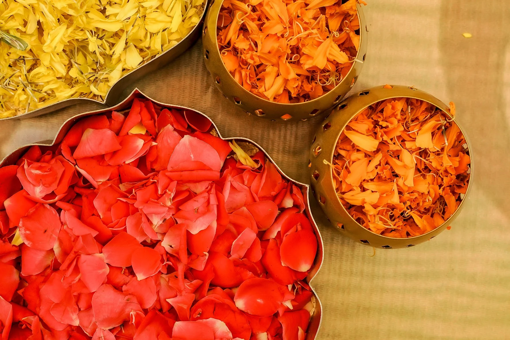 Bowls of yellow, orange and red flower petals prepared for a celebration