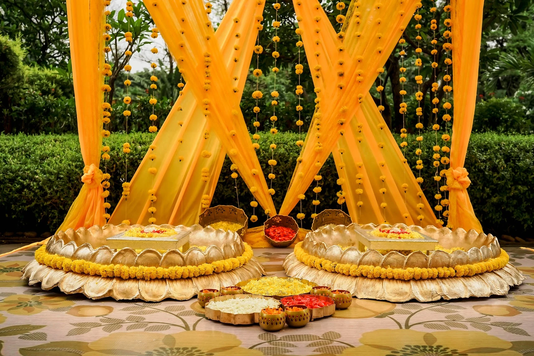 Yellow drapes, marigold garlands and traditional seats for a Haldi celebration