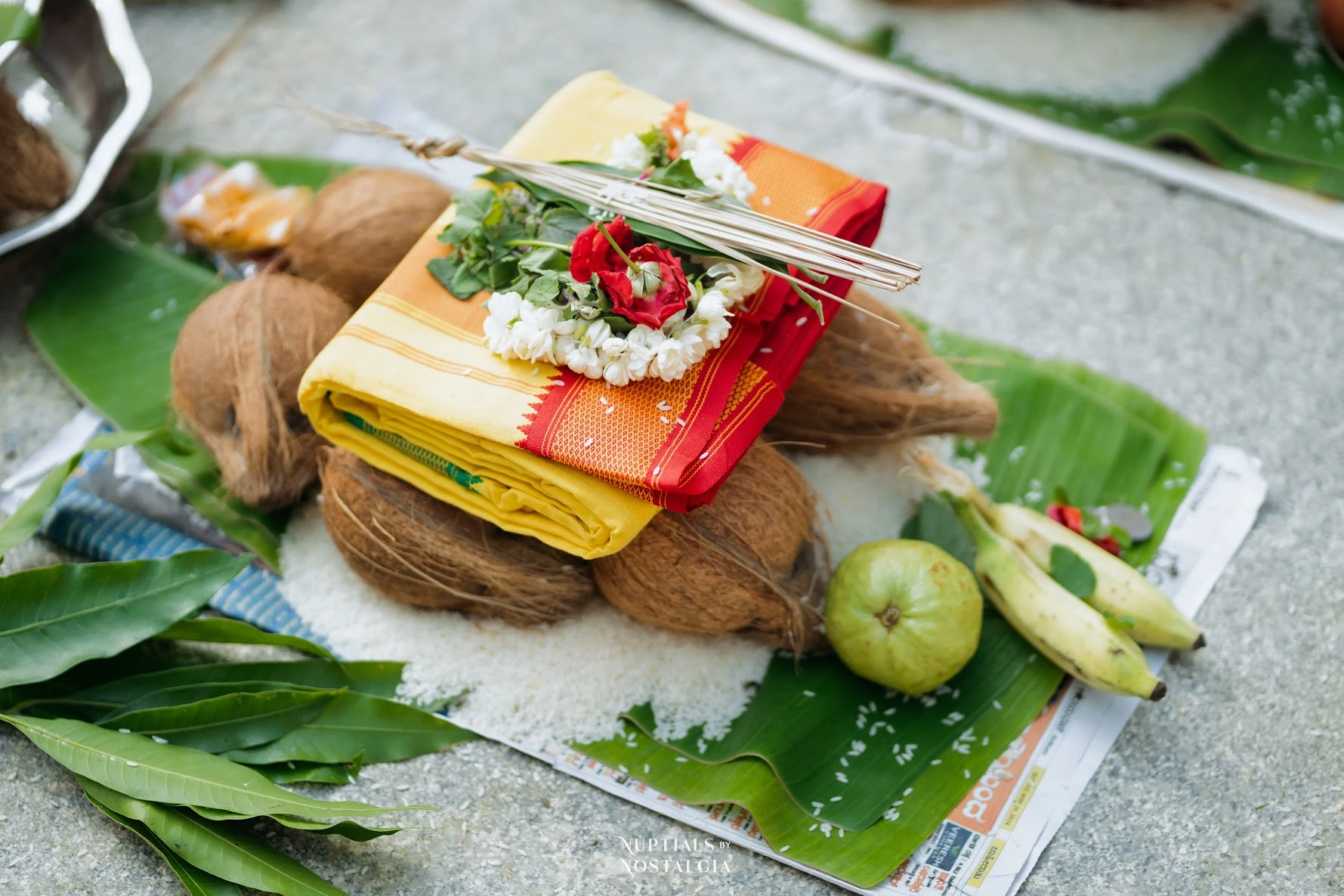 Ceremonial cloth, coconuts, fruit and flowers arranged on a banana leaf