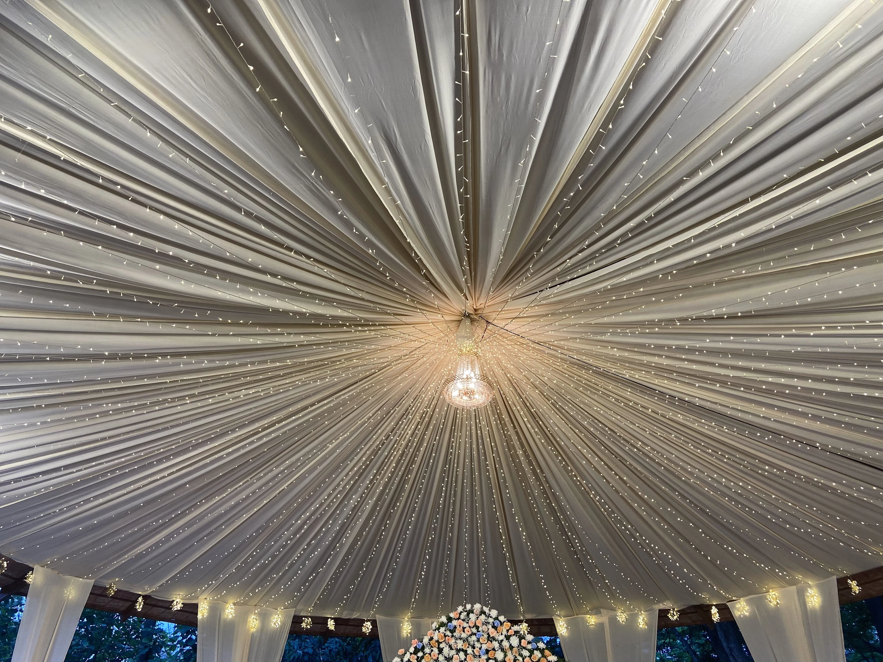 Pleated drapes and suspended lights above a reception setting