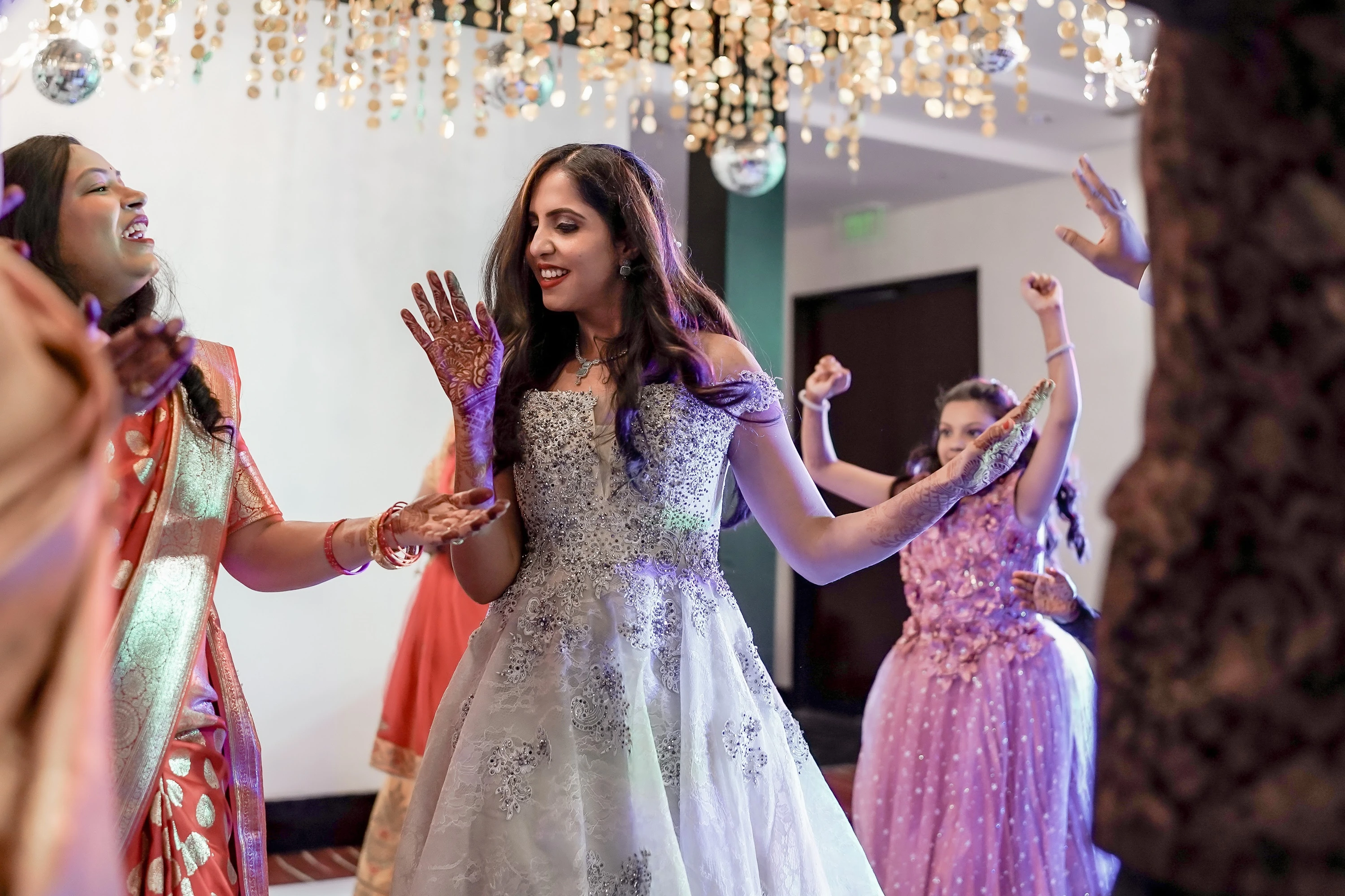 Family and guests dancing together during a sangeet celebration
