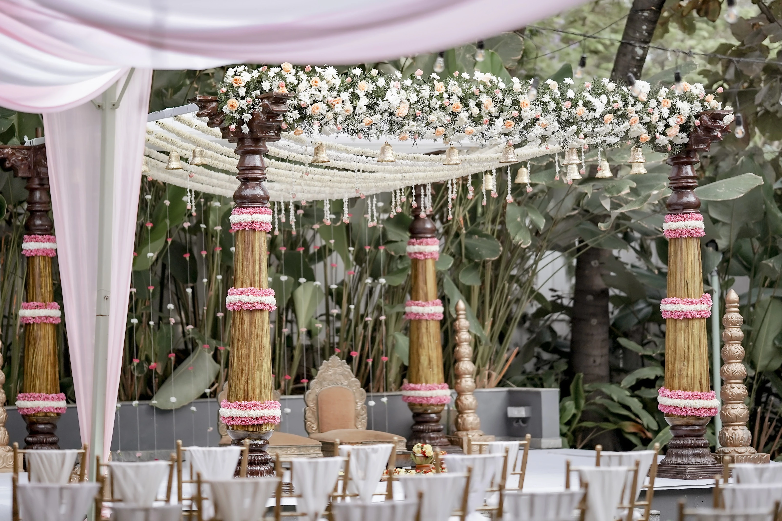 A garden mandap with ceremony seating arranged in front