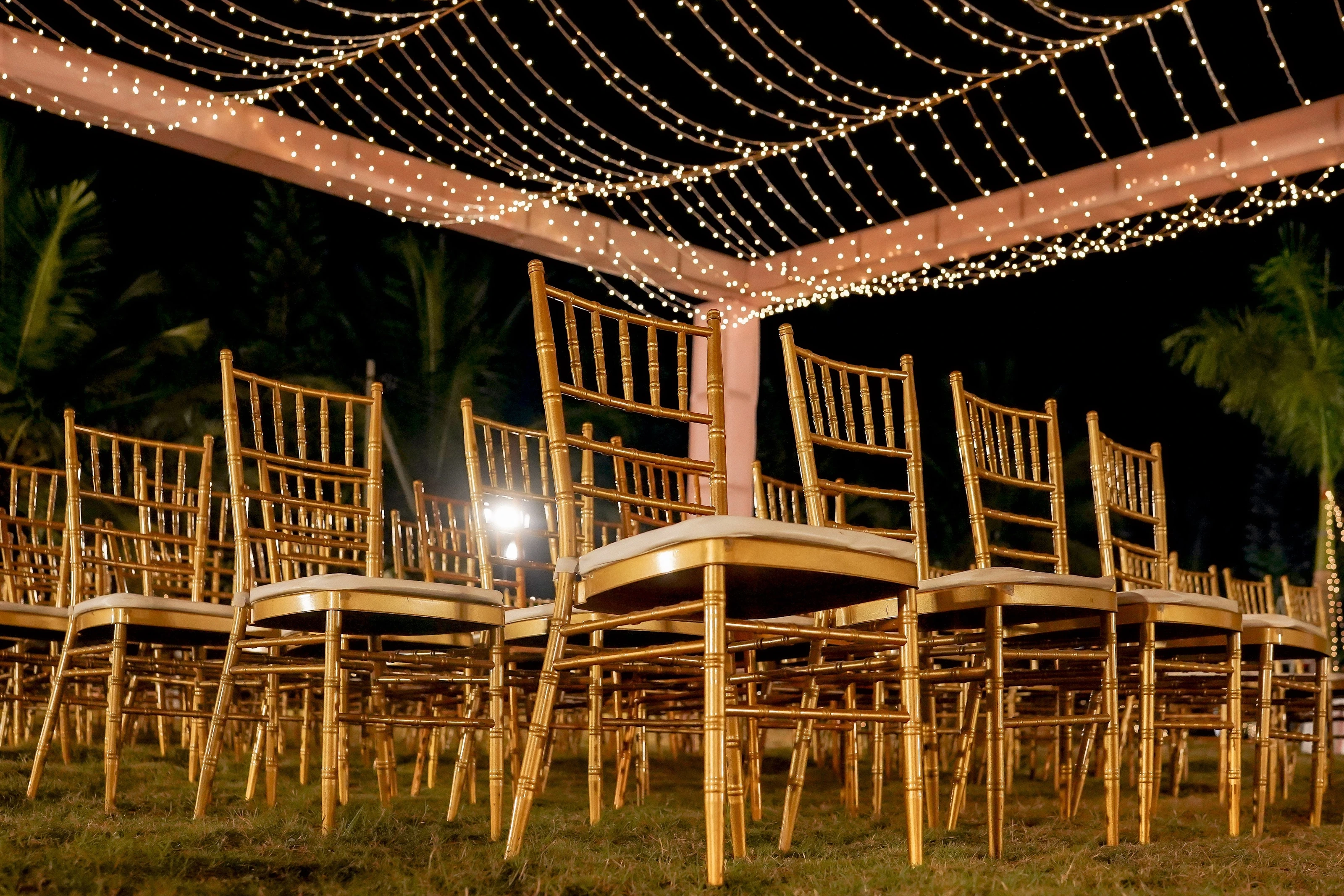 Guest chairs beneath strings of lights in an evening garden