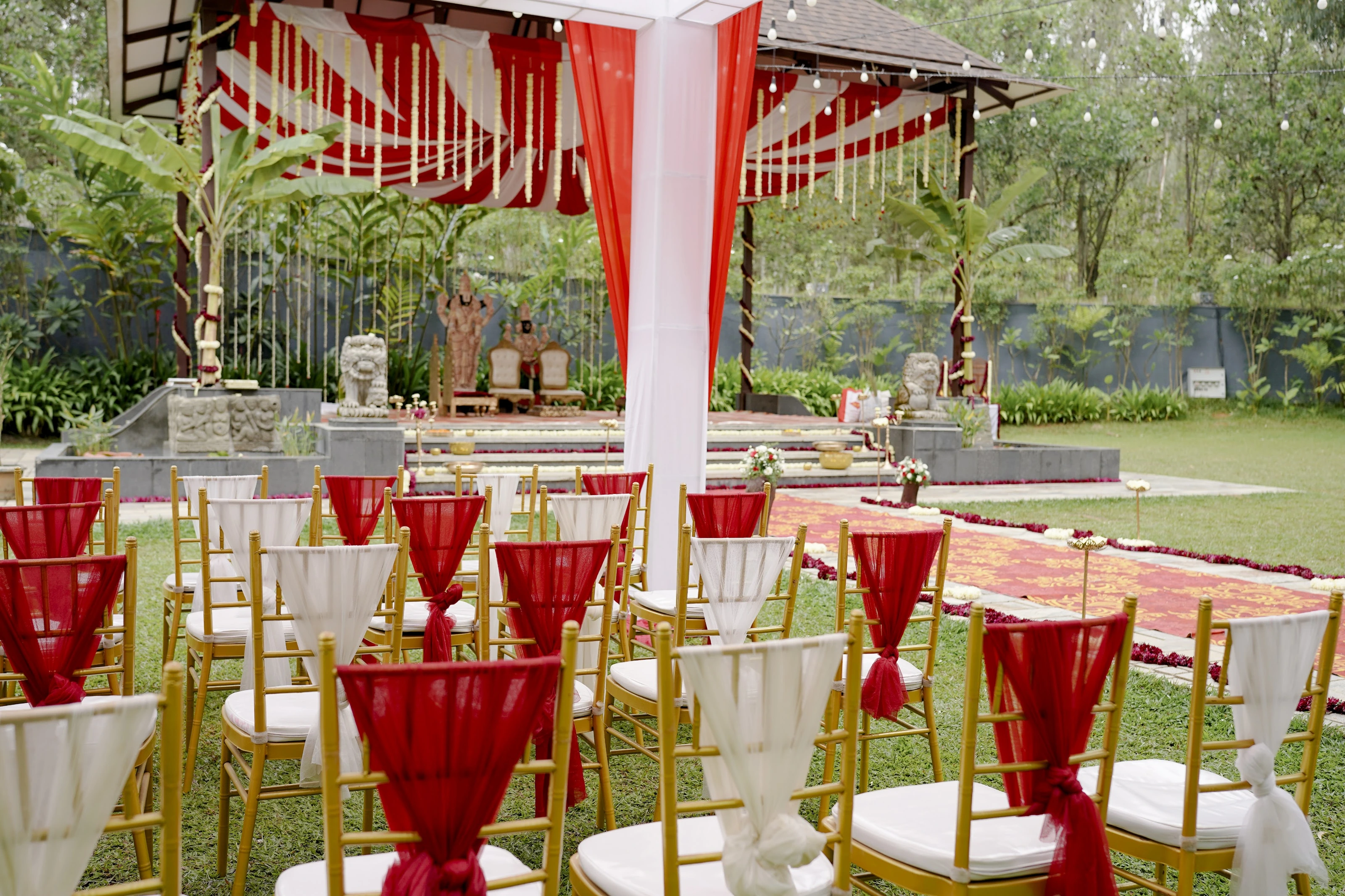 Rows of guest chairs arranged facing a garden ceremony pavilion