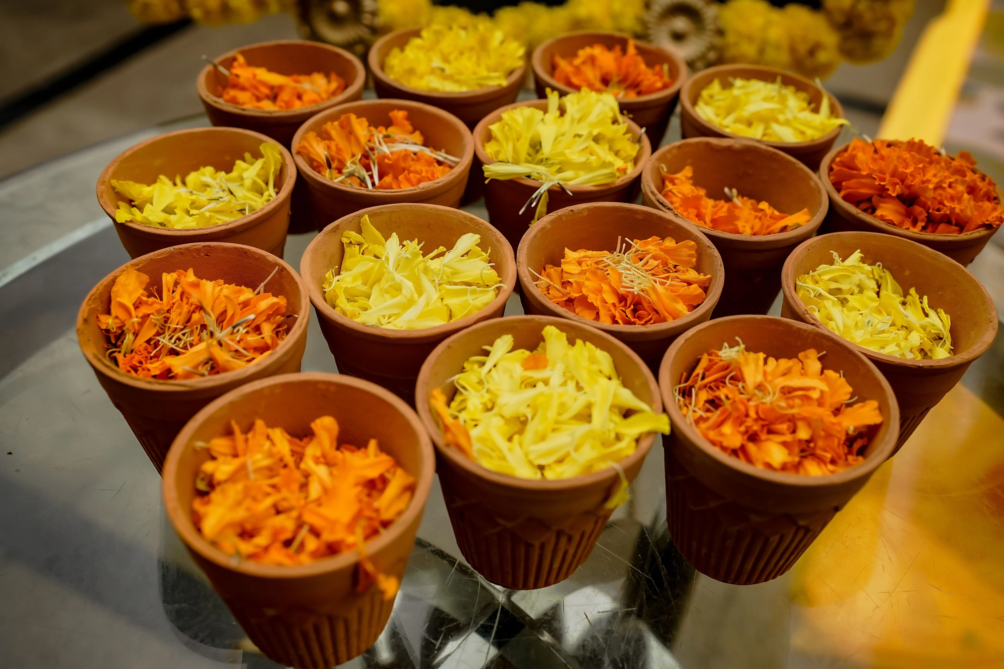 Small bowls of yellow and orange flower petals arranged for guests