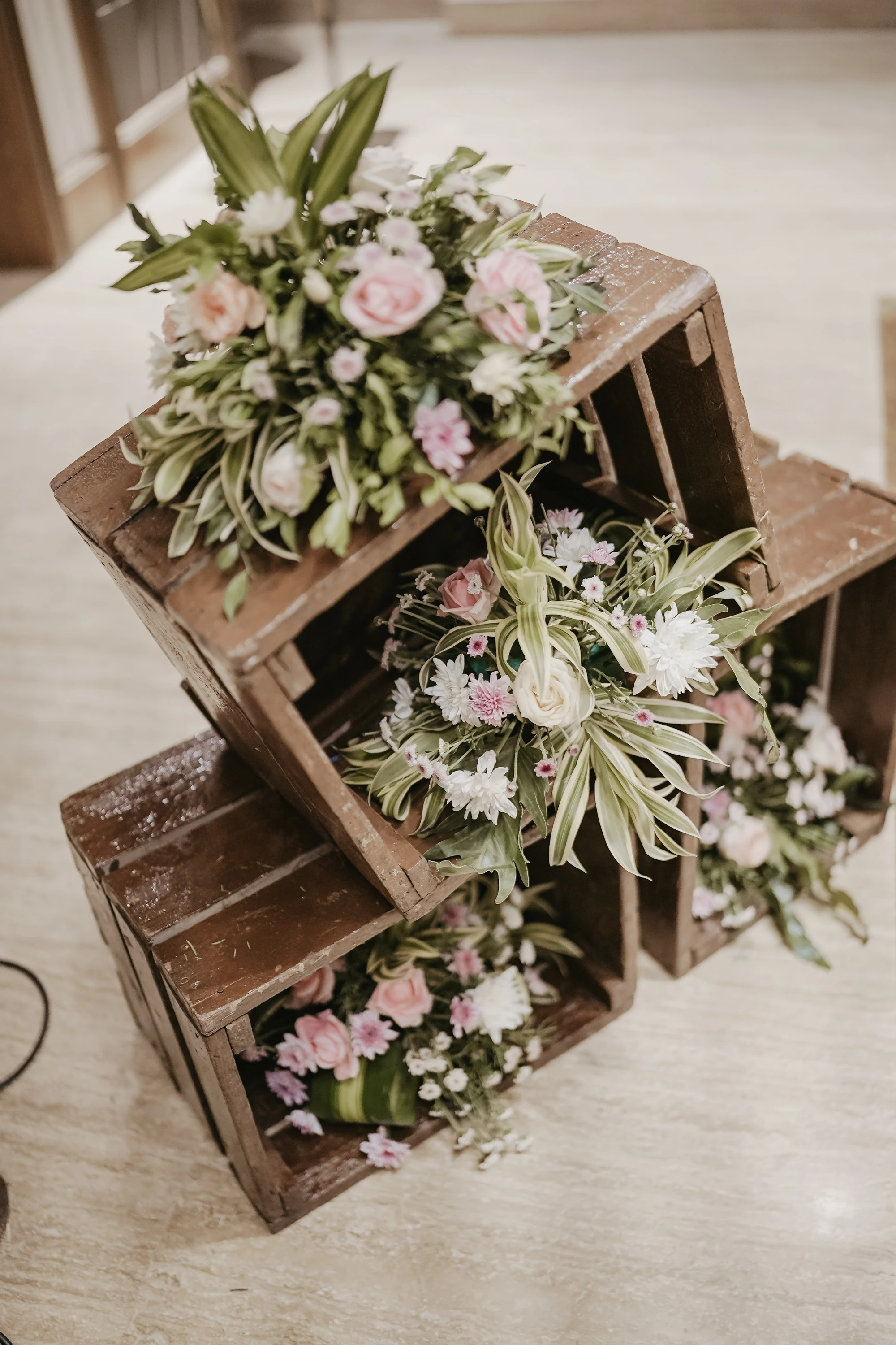 Pink and white flowers arranged inside open wooden display cubes